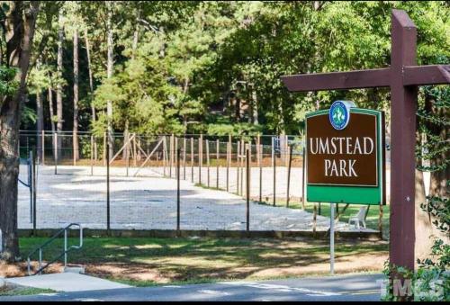 una señal frente a un parque inacabado con una valla en Lovely 2 Bedroom Condo with Pool, en Chapel Hill