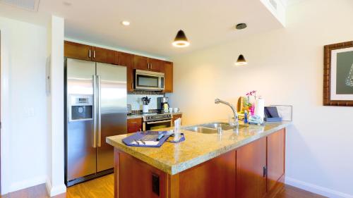 a kitchen with a sink and a refrigerator at Honua Kai - Konea 312 Mountain View 2BR/1BA in Kaanapali