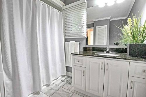 een witte badkamer met een wastafel en een douche bij Whispering Pines Riverside Retreat in Coboconk