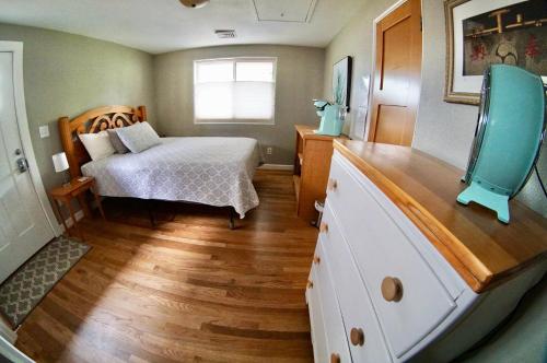 a bedroom with a bed and a dresser with a television at Steps Away in Eugene