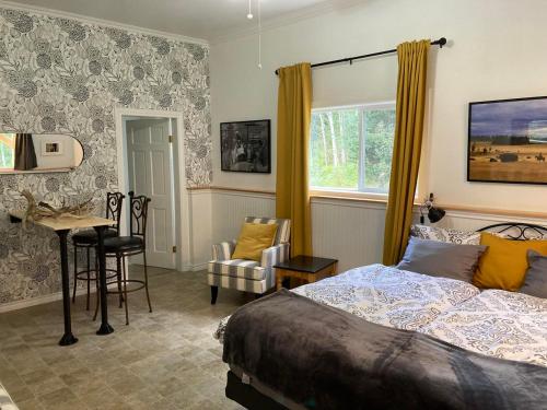 a bedroom with a bed and a table and a chair at Battle Creek Ranch, Wells Gray Park in Clearwater