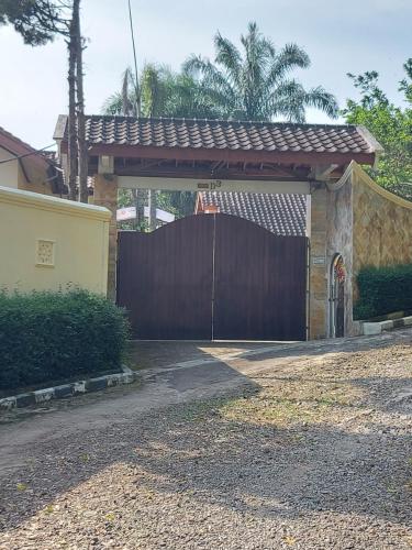 a wooden gate to a house with a fence at Villa D3 Bukit Cijulang in Bogor