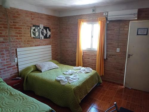 1 dormitorio con 2 camas y ventana en Complejo Navi, en Mina Clavero