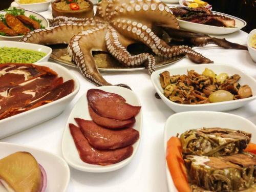a table with many plates of food and an octopus at Hotel Troya Balat in Istanbul