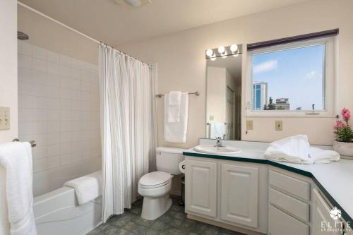 a bathroom with a toilet and a sink and a tub at Lavish 5 Star Modern Villa BEST Location in DOWNTOWN in Anchorage
