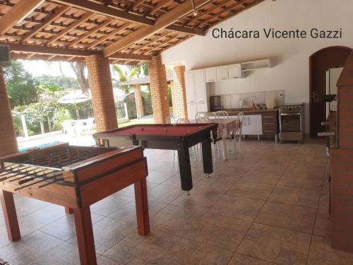 a living room with a pool table and a kitchen at Chácara Vicente Gazzi in Socorro