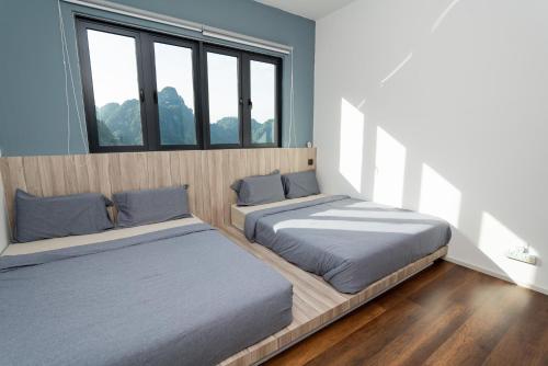 two beds in a room with two windows at Ipoh Tambun Lost World Sunway Onsen Suites Aria 2R2B 8 paxs in Tambun