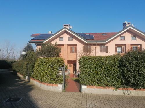 una grande casa con siepi verdi davanti di B&B- La Casa Blu- Forum di Assago, Humanitas, Milanofiori, IEO a Rozzano