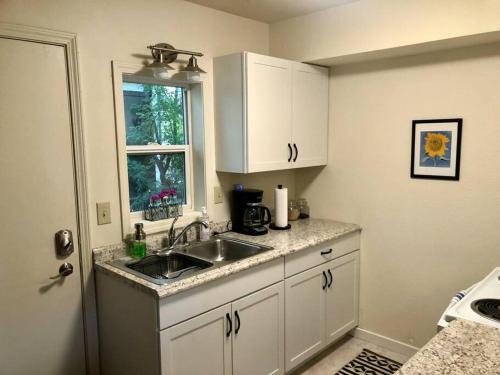 a kitchen with a sink and a window at 1915 Coastal Historical Log Home #1 Spot Downtown! in Anchorage