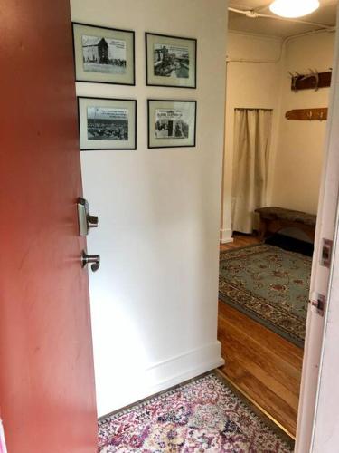 a hallway with a white door with pictures on the wall at Coastal Cabin - Downtown Historical Log Home in Anchorage