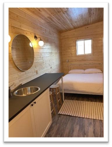 a bathroom with a sink and a bed in a cabin at Our Cabin Bed & Breakfast in Yellowknife