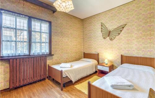 ポルレッツァにあるCasa Enzaのベッドルーム1室(ベッド2台付)が備わります。壁に蝶が描かれています。