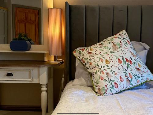 a pillow sitting on top of a bed next to a table at Bird In Bush Elsdon in Elsdon