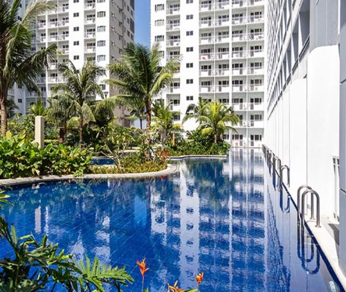 a swimming pool in the middle of a building with tall buildings at Shore Residences in Manila