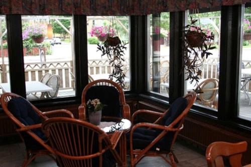 a room with chairs and a table and windows at Lagadalens Värdshus in Lagan