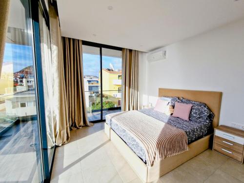 a bedroom with a bed and a large window at Praia Modern Apartment vista Mar in Praia
