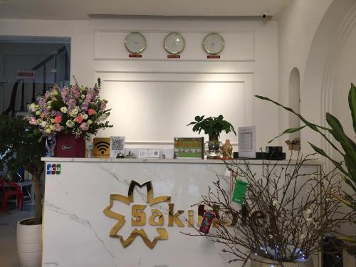 una habitación con dos relojes en la pared y flores en Keypad - Saki Hotel - 28 Dịch Vọng Hậu, Cầu Giấy en Hanói