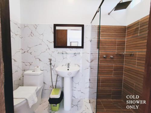 a bathroom with a sink and a toilet and a mirror at Meili Beach Resort in Alcoy