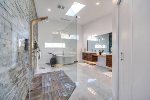 een badkamer met een douche, een bad en een wastafel bij The Infiniti Villa in Kelowna