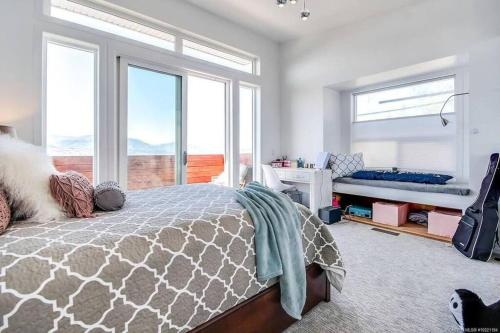 een slaapkamer met een bed en ramen met uitzicht bij The Infiniti Villa in Kelowna