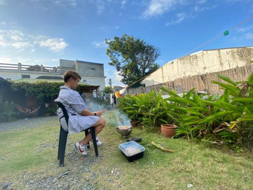 a man sitting in a chair flying a kite at Pacific Waves Inn (Annex) in Baler
