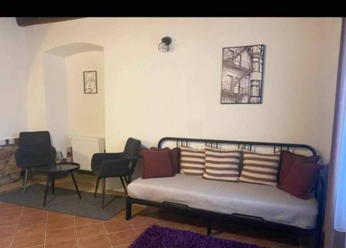 a living room with a bed and two chairs at Apartmány Vila Lucia 1 in Pilsen