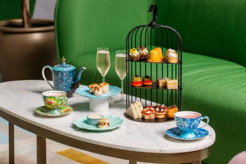 惠靈頓的住宿－Naumi Hotel Wellington，桌子,上面有杯子和盘子,食物和饮料