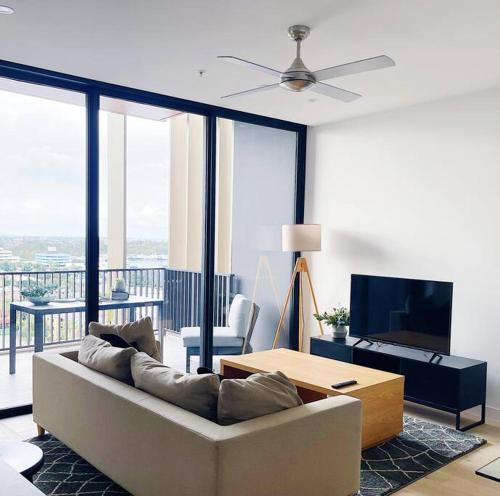 a living room with a couch and a flat screen tv at Chermside 3 beds apartment close to Hospital and Shops in Brisbane