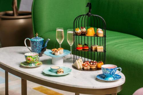 une table avec des tasses et des assiettes de nourriture et de boissons dans l'établissement Naumi Studio Wellington, à Wellington