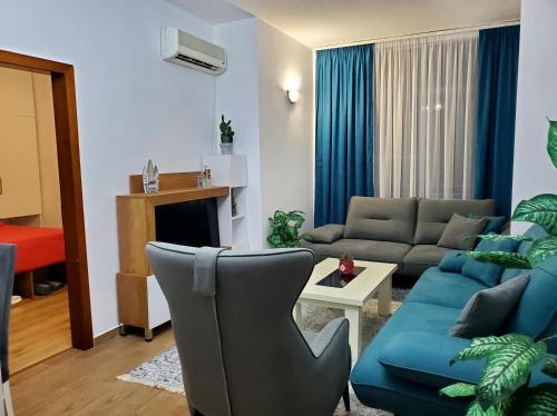 ein Wohnzimmer mit einem Sofa und ein Wohnzimmer mit einem blauen Sofa in der Unterkunft Roni Apartment in Durrës