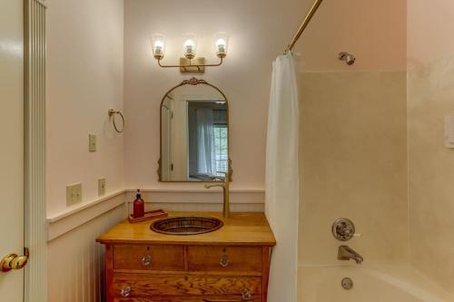 ein Badezimmer mit einem Waschbecken, einem Spiegel und einer Badewanne in der Unterkunft Bonne Terre Inn Crabapple 