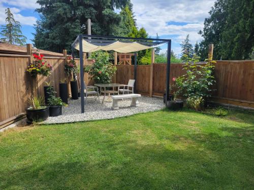 a backyard with a picnic table and a umbrella at JoyVeal’s Homey Place in Sechelt