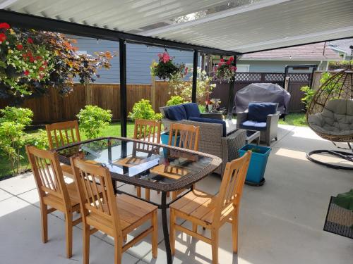 a patio with a table and chairs on a patio at JoyVeal’s Homey Place in Sechelt