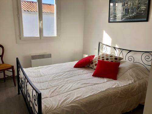 - une chambre avec un lit doté d'oreillers rouges dans l'établissement Maison Bretignolles-sur-Mer, 3 pièces, 4 personnes - FR-1-231-63, à Bretignolles-sur-Mer