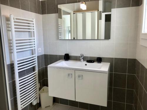 La salle de bains est pourvue d'un lavabo blanc et d'un miroir. dans l'établissement Maison Bretignolles-sur-Mer, 3 pièces, 4 personnes - FR-1-231-63, à Bretignolles-sur-Mer