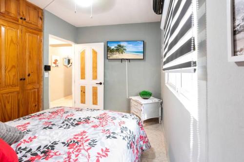 蓬塔卡納的住宿－Hermosa Suites #2 in the heart of PUNTA CANA，卧室配有一张床,墙上配有电视。