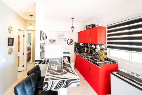 uma cozinha com armários vermelhos e uma bancada em Hermosa Suites #2 in the heart of PUNTA CANA em Punta Cana