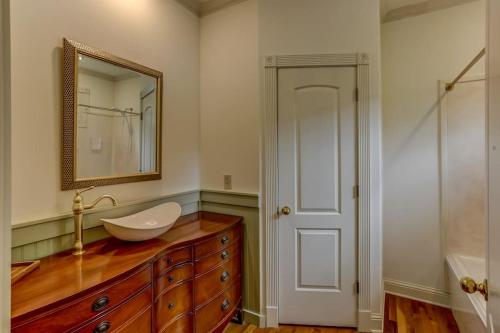 un bagno con lavandino e specchio su un comò di Bonne Terre Inn Maple Room 