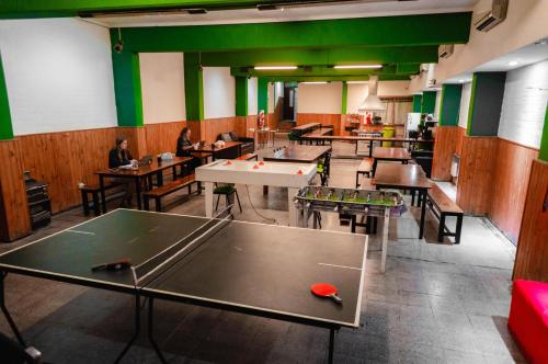 a room with tables and ping pong tables at Clover Hostel in Mendoza