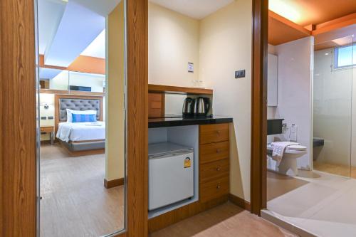 a bathroom with a kitchen and a bedroom with a bed at Golden Sea Hua Hin - SHA Extra Plus in Hua Hin