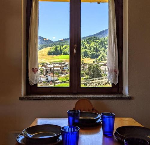 a table with blue glasses on it with a window at Alpine Vista Villa Hardaker 4 bedrooms Torgnon in Torgnon