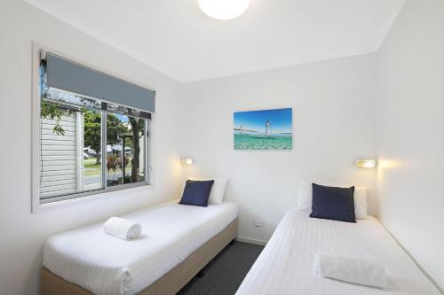 2 Betten in einem Zimmer mit Fenster in der Unterkunft Reflections Forster Beach - Holiday Park in Forster