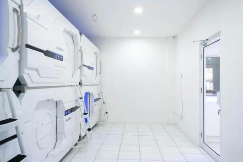 een wasruimte met witte wasmachines en drogers bij RedDoorz Hostel near Taman Puring in Jakarta