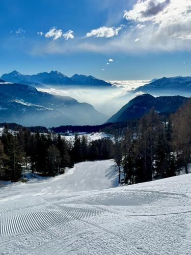 a snow covered slope with mountains in the distance at Alpine Vista Villa Hardaker 4 bedrooms Torgnon in Torgnon