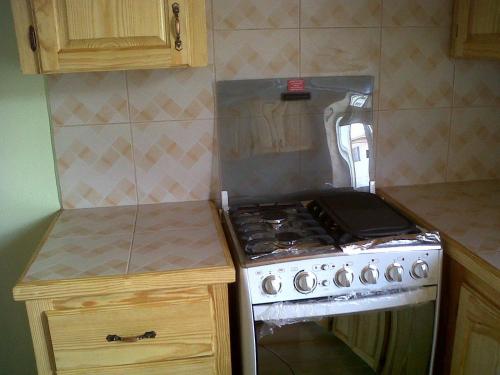 a kitchen with a stove and a counter top at Finch Apartment in Gwa Kay