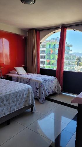 a hotel room with two beds and a large window at Apartamento 906 zona 9 in Guatemala