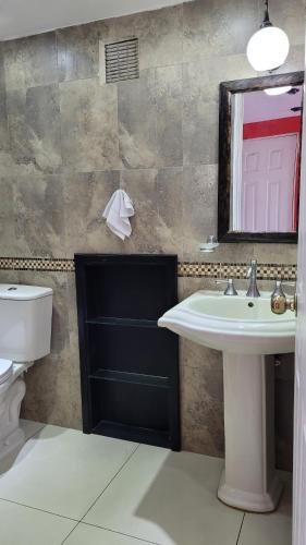 ein Badezimmer mit einem Waschbecken, einem WC und einem Spiegel in der Unterkunft Apartamento 906 zona 9 in Guatemala