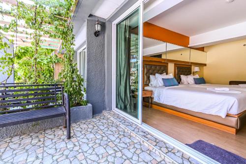 a bedroom with a bed and a balcony at Golden Sea Hua Hin - SHA Extra Plus in Hua Hin