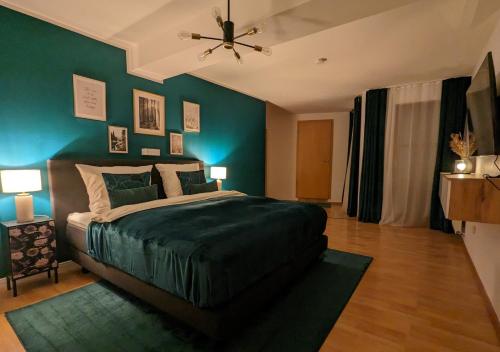 a bedroom with a bed with a green wall at FeWo Goldstück mit privatem SPA und Whirlpool in Grafenau