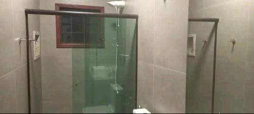 baño con ducha y puerta de cristal en Casa Nova em Ouro Preto e Mariana en Ouro Preto